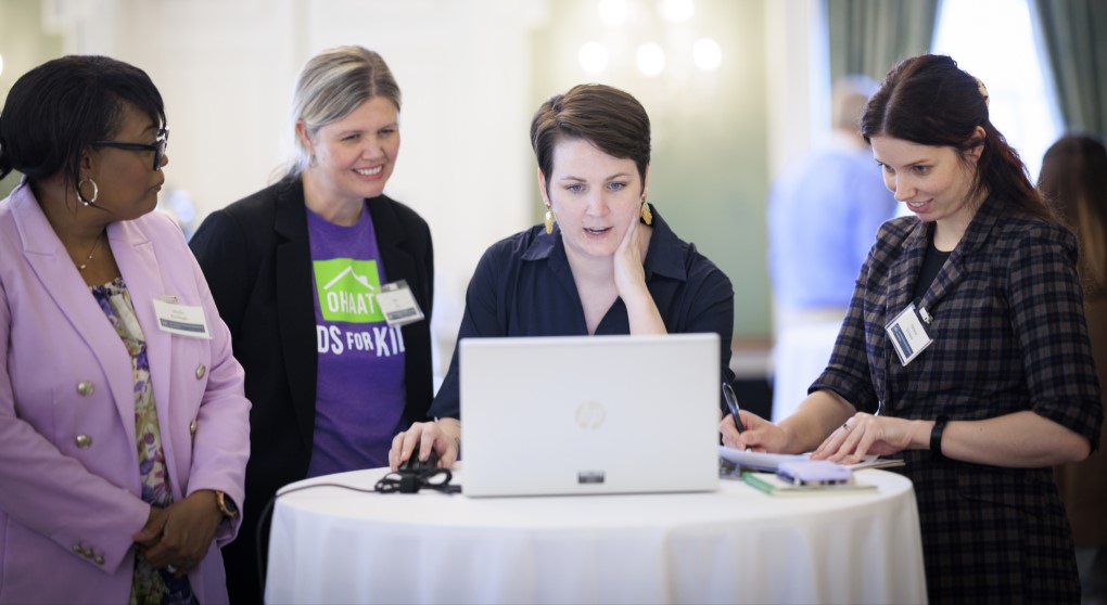 Participants collaborating around a laptop during a listening session